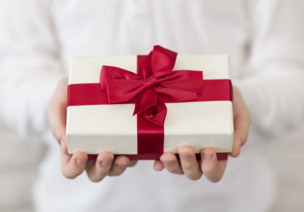 Boy holding wrapped gift for Mom