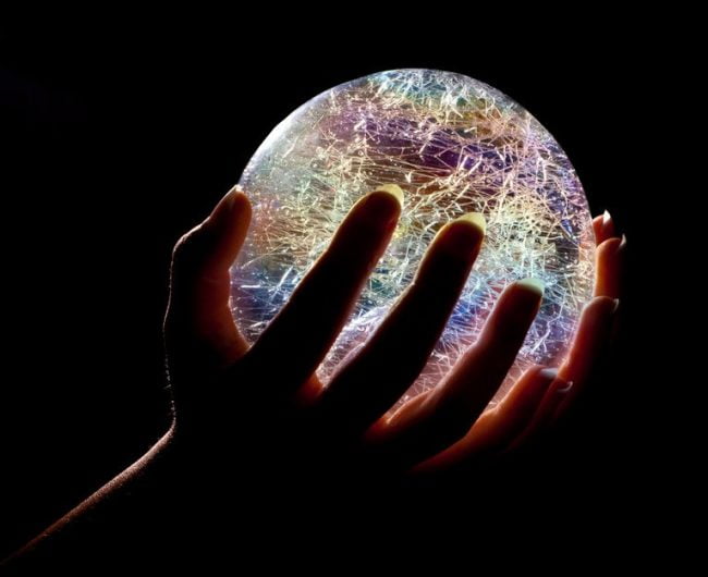 Future possibilities, symbolized by hands hold a bright, glowing glass ball