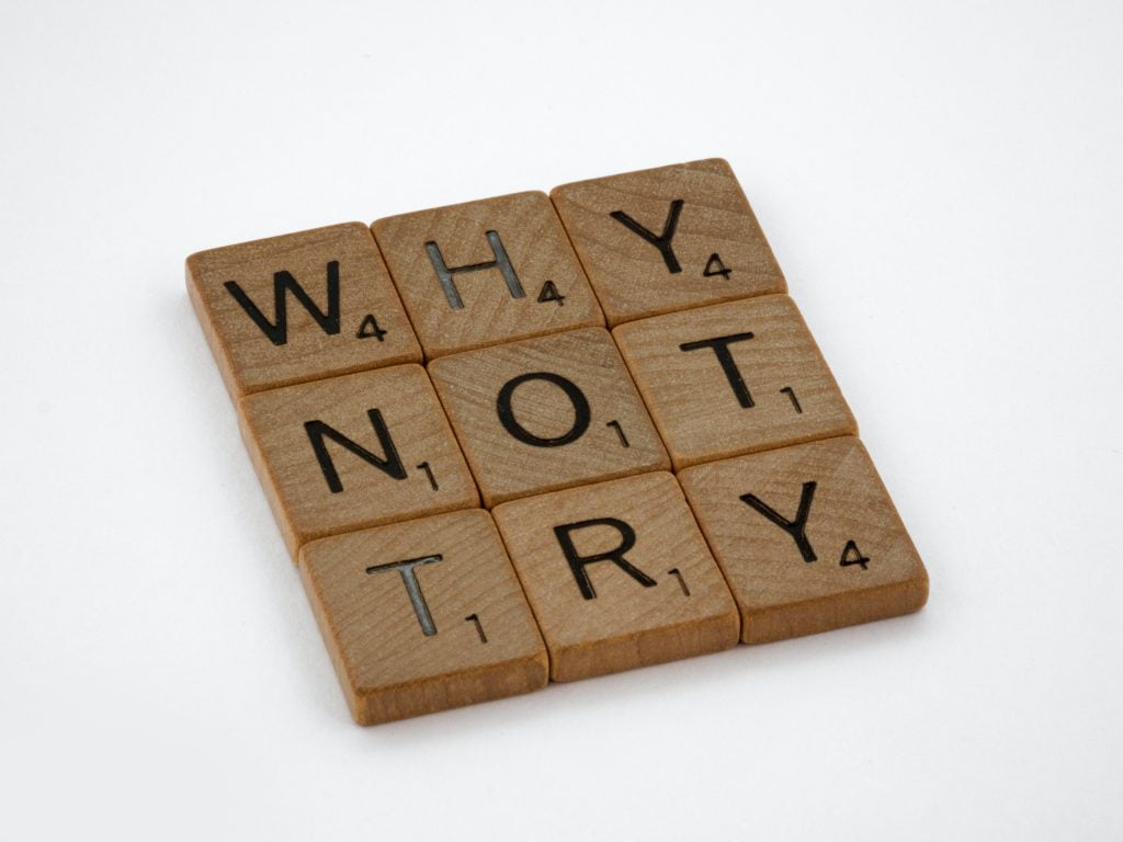 Scrabble tiles spelling out "Why Not Try"