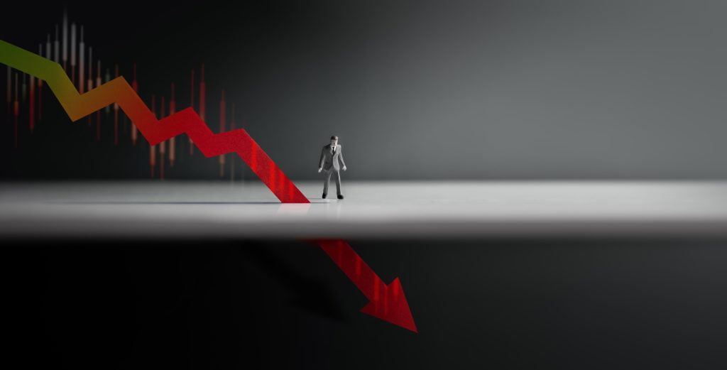 Downward pointing arrow indicating economic downturn, potential recession